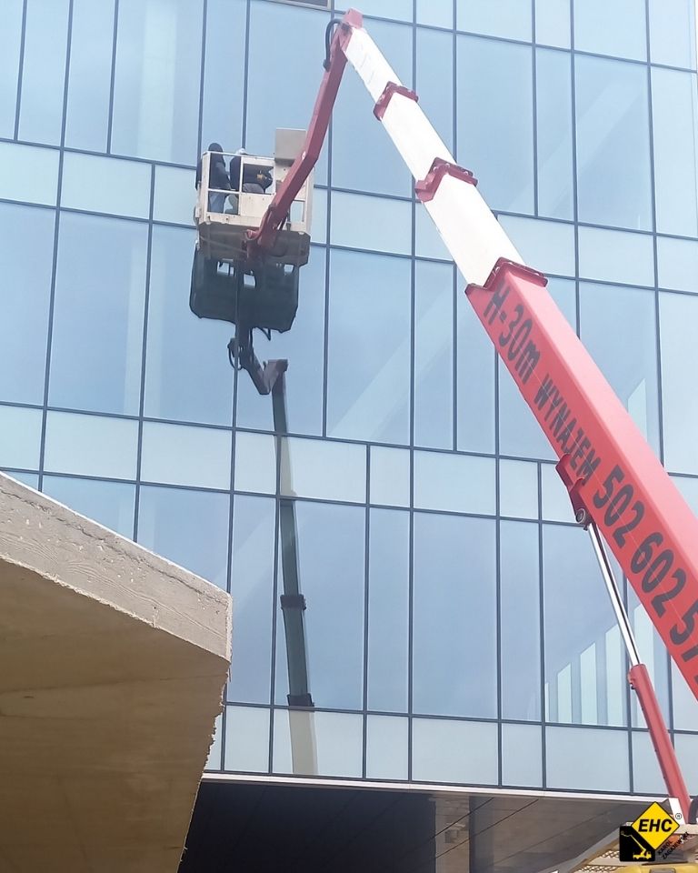 szklana elewacja a podnośnik koszowy
